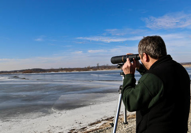Man with telescope observing a lake