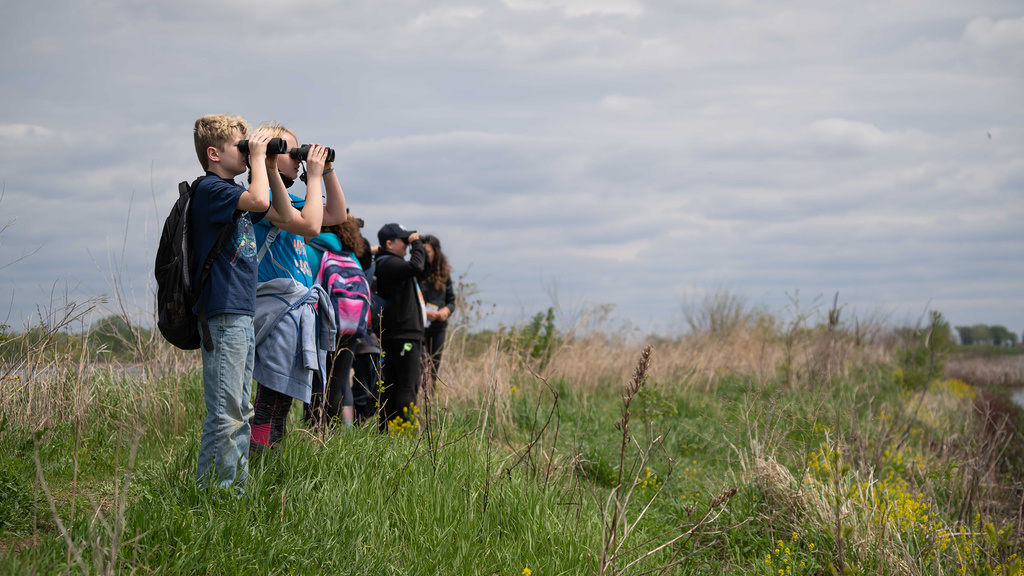 Students survey the landscape with binoculars during School of the Wild