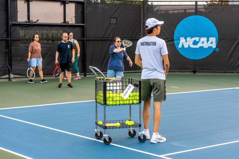 People participating in a green ball tennis class