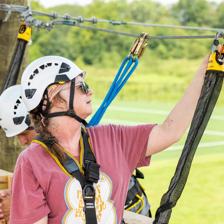 Participant clipping themself onto a line at the UI Challenge Course. 