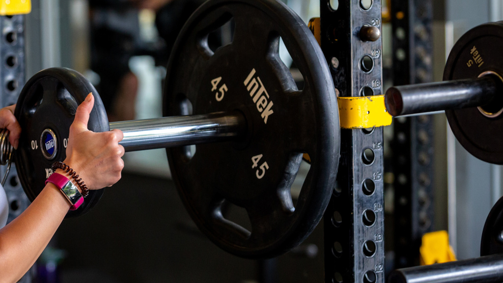 Lifter loading the barbell with weights. 